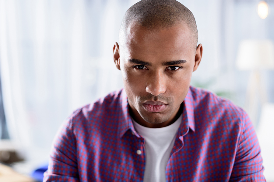 man with a serious look on his face wearing a plaid shirt